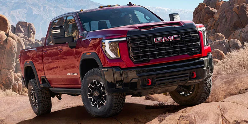 A red 2025 GMC Sierra HD off-roading.
