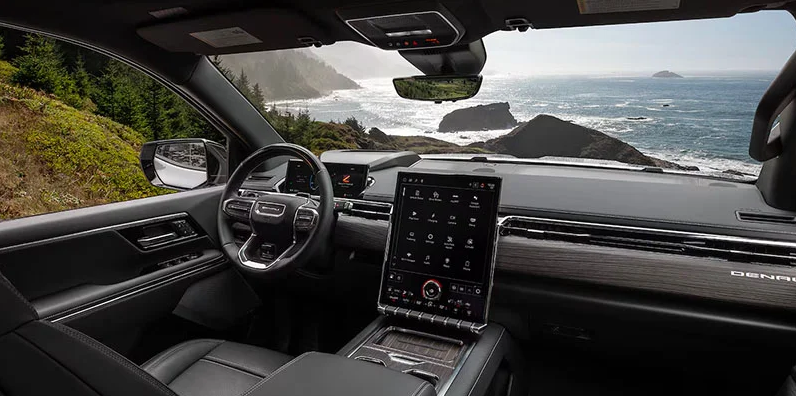 A photo of the inside of a 2025 GMC Sierra EV with an ocean view out the windshield.