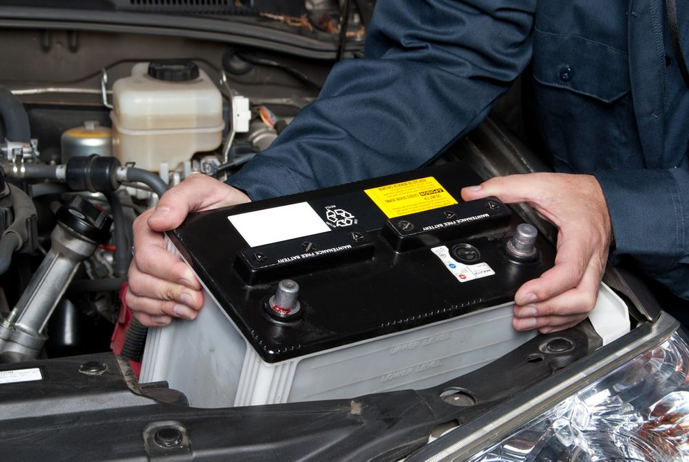 A man installing a new car battery.