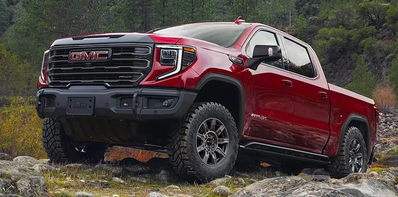 A red 2025 GMC Sierra 1500 off-roading. 