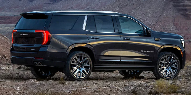 A 2025 GMC Yukon parked on a rocky parking lot.